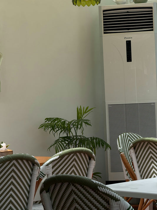 Chairs and tall air conditioner in a room.